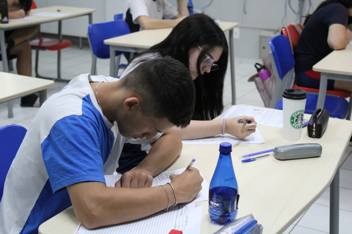 Alunos do Ensino Médio do Múltiplo escrevendo na carteira durante uma atividade avaliativa
