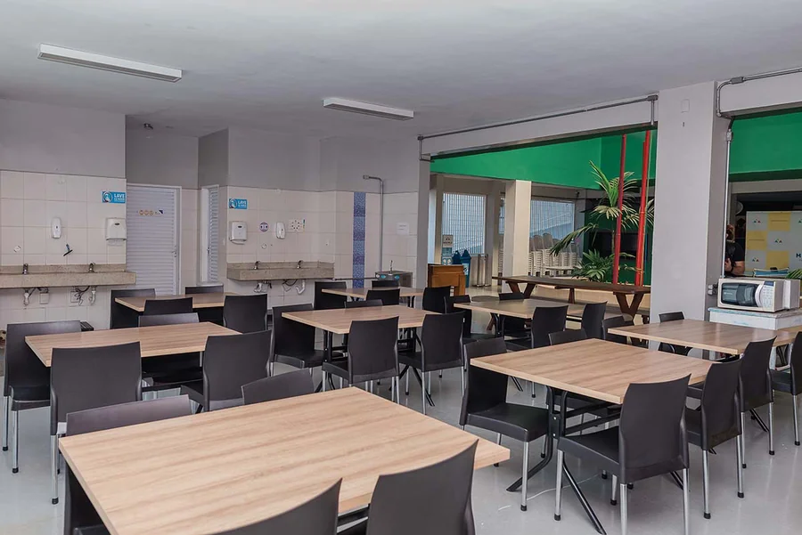 Sala de aula da unidade Múltiplo, com mesas de madeira e cadeiras vazias